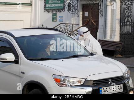 Kiew, Ukraine. April 2020. Ein Sanitäter überprüft die Temperatur eines Fahrers am Eingang zu Kiew Pechersk Lavra in Kiew, Kiew Pechersk Lavra Abschaltung für Quarantäne als COVID-19 Coronavirus Hot-bed. Am 13. April 2020 erklärte der Bürgermeister von Kiew, Witaliy Klitschko, dass die COVID-19 bestätigte Fälle im Kiewer Pechersk Lavra auf mehr als 90 angestiegen sind, darunter 63 Fälle, die am vergangenen Tag bestätigt wurden. Die Kiew Pechersk Lavra, die eine der wichtigsten orthodoxen Heiligtümer, seit ihrer Gründung als Höhlenkloster im Jahr 1051, die Lavra ist ein herausragendes Zentrum der östlichen orthodoxen Christentum im Osten Stockfoto