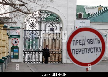 Kiew, Ukraine. April 2020. Ein Mann schaut durch einen geschlossenen Eingang zum Kiewer Pechersker Lavra in Kiew.Kiewer Pechersker Lavra macht sich zur Quarantäne als das COVID-19 Coronavirus-Brutstätte. Am 13. April 2020 erklärte der Bürgermeister von Kiew, Witaliy Klitschko, dass die COVID-19 bestätigte Fälle im Kiewer Pechersk Lavra auf mehr als 90 angestiegen sind, darunter 63 Fälle, die am vergangenen Tag bestätigt wurden. Die Kiew Pechersk Lavra, die eine der wichtigsten orthodoxen Heiligtümer, seit ihrer Gründung als Höhlenkloster im Jahr 1051, die Lavra ist ein herausragendes Zentrum der östlichen orthodoxen Christentum in Osteuropa. Kredit: SO Stockfoto