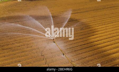 Luftaufnahme Bewässerungssystem Maschine mit Drehmittelpunkt Sprinkleranlage. Eine beregnungsachse Bewässerung landwirtschaftlicher Flächen. Bewässerung Bewässerung farm Land. Stockfoto