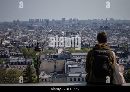 Paris, Frankreich. April 2020. Ein Mann schaut auf die Stadt Paris am Montmartre in Paris, Frankreich, 13. April 2020. Frankreich werde bis Mai 11 unter einer landesweiten Lockdown-Regierung stehen, um die Ausbreitung von COVID-19 einzudämmen und seine Auswirkungen auf die heimischen Gesundheitseinrichtungen zu verringern, sagte Präsident Emmanuel Macron am Montagabend. Kredit: Aurelien Morissard/Xinhua/Alamy Live News Stockfoto