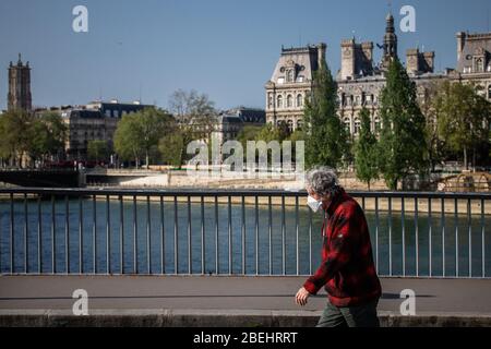 Paris, Frankreich. April 2020. Ein Bewohner, der eine Maske trägt, geht auf der Straße in Paris, Frankreich, 13. April 2020. Frankreich werde bis Mai 11 unter einer landesweiten Lockdown-Regierung stehen, um die Ausbreitung von COVID-19 einzudämmen und seine Auswirkungen auf die heimischen Gesundheitseinrichtungen zu verringern, sagte Präsident Emmanuel Macron am Montagabend. Kredit: Aurelien Morissard/Xinhua/Alamy Live News Stockfoto