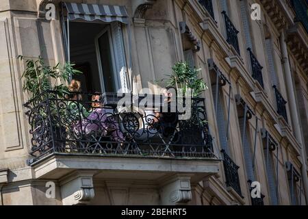 Paris, Frankreich. April 2020. Die Menschen genießen sich auf dem Balkon in Paris, Frankreich, 13. April 2020. Frankreich werde bis Mai 11 unter einer landesweiten Lockdown-Regierung stehen, um die Ausbreitung von COVID-19 einzudämmen und seine Auswirkungen auf die heimischen Gesundheitseinrichtungen zu verringern, sagte Präsident Emmanuel Macron am Montagabend. Kredit: Aurelien Morissard/Xinhua/Alamy Live News Stockfoto
