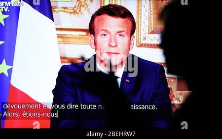 Paris, Frankreich. April 2020. Ein Zuschauer sieht Fernsehen, während der französische Präsident Emmanuel Macron während einer Fernsehansprache vom 13. April 2020 in Paris, Frankreich, aus dem Elysee-Palast spricht. Frankreich werde bis Mai 11 unter einer landesweiten Lockdown-Regierung stehen, um die Ausbreitung von COVID-19 einzudämmen und seine Auswirkungen auf die heimischen Gesundheitseinrichtungen zu verringern, sagte Präsident Emmanuel Macron am Montagabend. "Die Epidemie beginnt sich zu verlangsamen. Die Ergebnisse sind da. Kredit: Xinhua/Alamy Live News Stockfoto