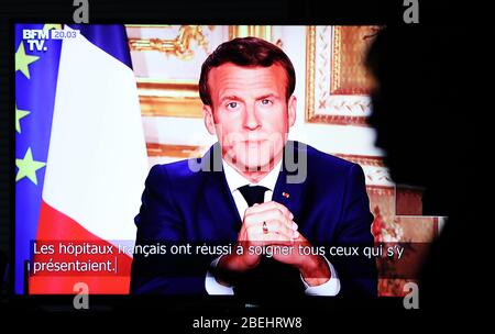 Paris, Frankreich. April 2020. Ein Zuschauer sieht Fernsehen, während der französische Präsident Emmanuel Macron während einer Fernsehansprache vom 13. April 2020 in Paris, Frankreich, aus dem Elysee-Palast spricht. Frankreich werde bis Mai 11 unter einer landesweiten Lockdown-Regierung stehen, um die Ausbreitung von COVID-19 einzudämmen und seine Auswirkungen auf die heimischen Gesundheitseinrichtungen zu verringern, sagte Präsident Emmanuel Macron am Montagabend. "Die Epidemie beginnt sich zu verlangsamen. Die Ergebnisse sind da. Kredit: Xinhua/Alamy Live News Stockfoto