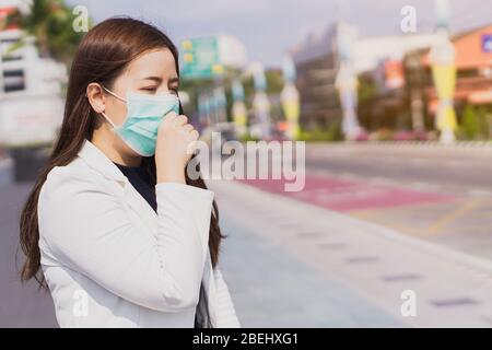 Das Mädchen, das eine Maske zum Schutz von Coronavirus und 2,5 Uhr trägt, hustet die Grippe vor Coronavirus. Coronavirus und Luftverschmutzung PM 2,5 conce Stockfoto