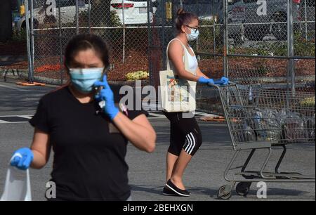 Kissimmee, Vereinigte Staaten. April 2020. 13. April 2020 - Kissimmee, Florida, Vereinigte Staaten - Menschen tragen Gesichtsmasken außerhalb eines Geschäfts in Kissimmee, Florida am 13. April 2020, dem ersten Tag, dass lokale Beamte in Osceola County, Florida in der Nähe von Orlando machte das Tragen von Gesichtsbezügen in der Öffentlichkeit obligatorisch, um die Ausbreitung der COVID-19 Pandemie einzudämmen. Kredit: Paul Hennessy/Alamy Live News Stockfoto