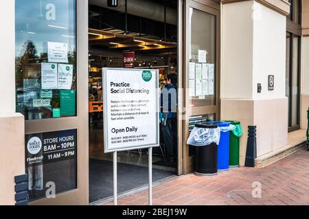 April 9, 2020 Santa Clara / CA / USA - Sign in am Eingang zu einem Whole Foods Market Store, fordert Kunden auf, Social Distancin zu üben Stockfoto