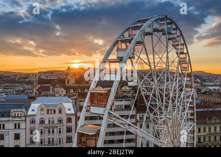 Budapest, Hungary - Luftaufnahme des berühmten Riesenrads von Budapest mit dem Budaer Schloss Königspalast und einem erstaunlichen goldenen Sonnenuntergang und Himmel auf dem Rücken Stockfoto