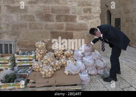 Ein religiöser Jude mit Schutzmaske schenkte Lebensmittelpakete im jüdischen Viertel in der Altstadt von Jerusalem inmitten von Einschränkungen aufgrund der Coronavirus (COVID-19) Pandemie in der Altstadt von Jerusalem Israel Stockfoto