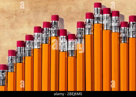 Ein Business-Balkendiagramm, das aus der Radiergummi-Seite von gelben #2 Bleistiften auf einem schmutzigen Leinenfaserpapier-Hintergrund besteht und über dem Diagramm auf dem Th Platz für Kopie bietet Stockfoto