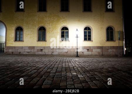 Leere Straße in der Nacht im Licht der altmodischen Straßenlampe. Stockfoto