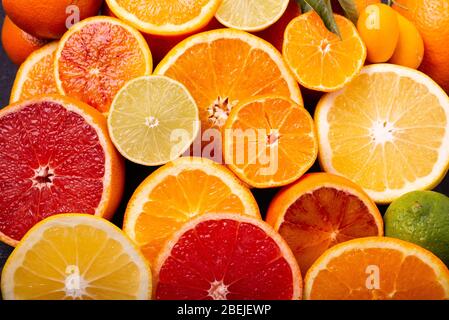 Verschiedene Arten von Zitrusfrüchten in Scheiben geschnitten und im Vordergrund angeordnet Stockfoto