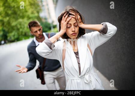 Aufbruch des Paares mit Mann und trauriger Freundin im Freien. Scheidung, Paar, Liebe, Schmerzkonzept. Stockfoto