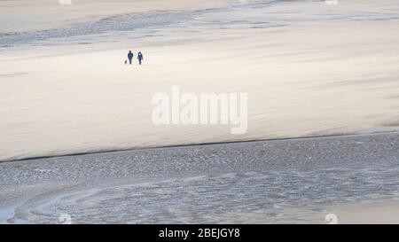 Ein Panoramablick auf Hundewanderer am preisgekrönten Crantock Beach in Newquay in Cornwall. Stockfoto