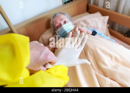 Eine alte Frau liegt mit einer Gesichtsmaske in ihrem Bett Stockfoto