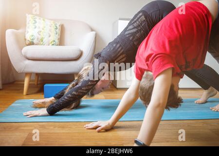 Kleiner Junge zusammen mit seiner Mutter Yoga zu Hause während der Quarantäne Stockfoto