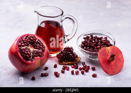 Saftiger und frischer Granatapfel, mit Samen und Granatapfelsaft in einer Glaskaraffe Stockfoto