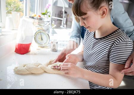 Mutter Und Tochter Haben Spaß In Der Küche Am Flechten Teig Für Home Baked Brot Zusammen Stockfoto