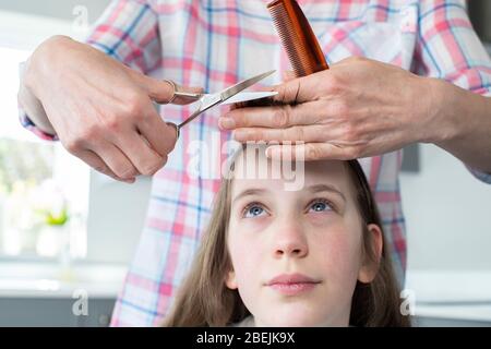 Mutter Schneidet Besorgte Töchter Haare Zu Hause Während Lockdown Stockfoto