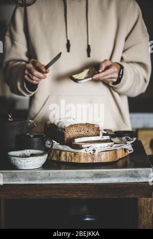 Frau, die Butter auf gesunde Roggen schwedische Brot Scheibe verteilt Stockfoto