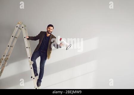 Geschäftsmann auf der Treppe mit einem Megaphon in der Hand schreit Stockfoto