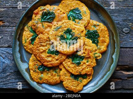 Nützliche würzige indische Kichererbsen Pfannkuchen mit Gemüse und Petersilie in einem Teller Draufsicht Stockfoto