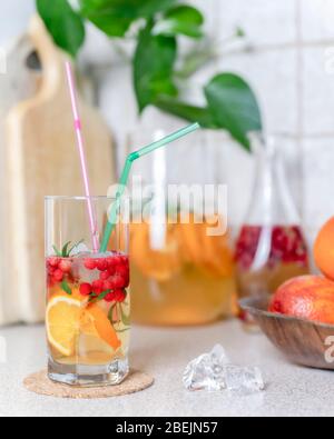 Hausgemachte Limonade mit Zitrone, Orange und Cranberry mit Eis im Glas und Krug auf dem Tisch. Sommer kaltes erfrischendes Getränk. Stockfoto
