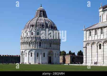 Pisa, Italien - März 31 2019: Piazza dei Miracoli mit dem Baptisterium von Pisa, der Kathedrale von Pisa und einem Teilblick auf die Stadtmauern. Stockfoto