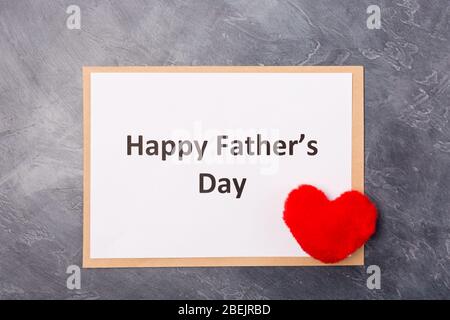 Happy Father's Day Text auf grauem Hintergrund mit rotem Herz. Freier Speicherplatz. Platz für Text. Vatertag Feiertagskonzept. Stockfoto