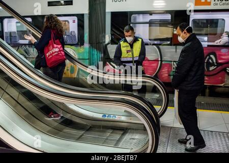 Barcelona, Katalonien, Spanien. 14. Apr 2020 - EIN Wachmann kontrolliert die Entfernung zwischen Pendlern auf Rolltreppen am Bahnhof Catalunya in Barcelona. Tausende von Menschen kehren zur Arbeit zurück, nachdem die spanische Regierung die strengsten Maßnahmen der Coronavirus-Haft aufzuheben hat. Quelle: Jordi Boixareu/Alamy Live News Stockfoto