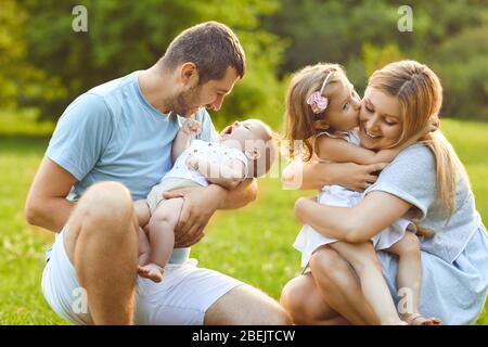 Mutter Vater und Kinder, die in der Natur auf dem Gras spielen Stockfoto