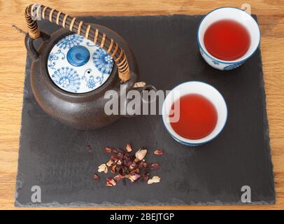 Zwei Tassen Hagebutte Tee von oben mit Teekanne und Blättern genommen Stockfoto