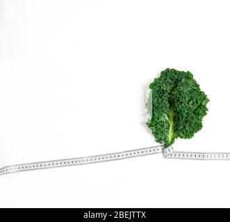 Kale eingewickelt in Maßband, Konzept Diät, Abnehmen, gesunde Ernährung, oben Stockfoto