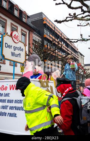 Sicherheitsdienst hält Mann vor einem Wagen bei der Rosenmontagsparade in Mainz zurück. Stockfoto