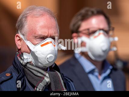 Schwerin, Deutschland. April 2020. Thomas Lenz, Staatssekretär im Ministerium des Innern des Landes Mecklenburg-Vorpommern, nimmt mit einer Gesichtsmaske die Sammlung von 1,500 Unterschriften von Mitgliedern der Initiative Pro Bleiberecht entgegen. Die Petition fordert das Recht, sich in Unterkünften für Asylsuchende zu aufhalten. Das Verwaltungsgericht hatte zuvor ein Versammlungsverbot aufgehoben. Quelle: Jens Büttner/dpa-Zentralbild/dpa/Alamy Live News Stockfoto