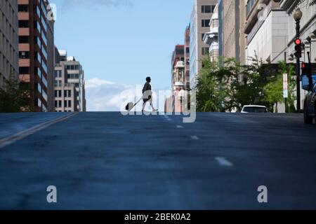 Washington, DC, USA. April 2020. Eine Frau überquert eine Straße in Washington, DC, USA, 13. April 2020. Kredit: Liu Jie/Xinhua/Alamy Live News Stockfoto