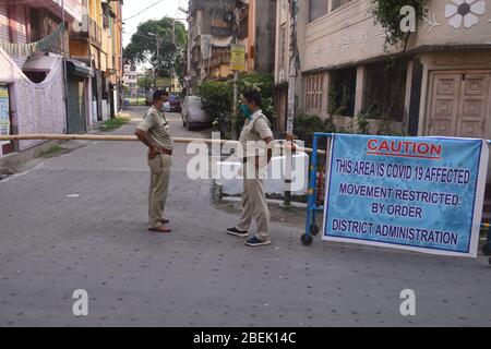 Kalkutta, Indien. April 2020. Polizisten stehen Wache vor einem Wohngebiet unter Sperrungsschutz wegen der COVID-19 in Kalkutta, Indien, 13. April 2020. Der indische Premierminister Narendra Modi hat am Dienstag die landesweite Sperrung bis zum 3. Mai inmitten der COVID-19-Pandemie verlängert. Kredit: Str/Xinhua/Alamy Live News Stockfoto