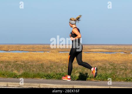 Southport, Merseyside, Großbritannien. April 2020. UK Coronavirus: Die Einheimischen nehmen an einem sonnigen Frühlingstag an der Strandpromenade mit Blick auf das Naturschutzgebiet Ribble Estuary leichte Übungen, während England seine vierte Woche in der Absperrung beginnt. Quelle: MediaWorldImages/AlamyLiveNews Stockfoto