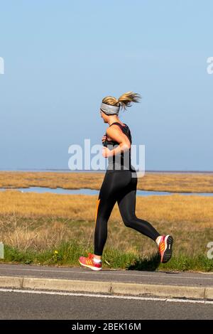 Southport, Merseyside, Großbritannien. April 2020. UK Coronavirus: Die Einheimischen nehmen an einem sonnigen Frühlingstag an der Strandpromenade mit Blick auf das Naturschutzgebiet Ribble Estuary leichte Übungen, während England seine vierte Woche in der Absperrung beginnt. Quelle: MediaWorldImages/AlamyLiveNews Stockfoto