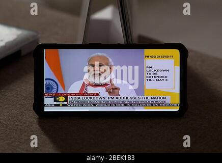 Neu Delhi, Indien. April 2020. Ein Film auf einem Mobiltelefon zeigt den indischen Premierminister Narendra Modi, der in einer Fernsehrede in Neu-Delhi, Indien, am 14. April 2020 die Nation anspricht. Modi verlängerte am Dienstag die landesweite Sperre bis zum 3. Mai inmitten der COVID-19-Pandemie. Kredit: Javed Dar/Xinhua/Alamy Live News Stockfoto