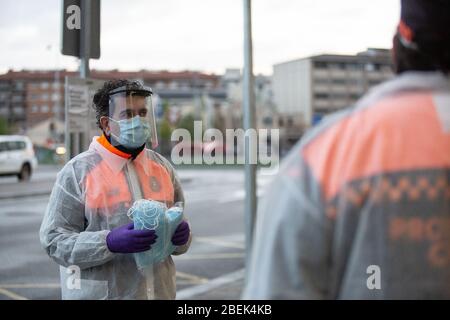 Girona, Spanien. April 2020. Ein spanisches Mitglied des Zivilschutzes, das sich darauf vorbereitet, Gesichtsmasken als vorbeugende Maßnahme gegen die Ausbreitung des Coronavirus (COVID-19) am Bahnhof von Girona zu verteilen.die spanische Regierung stellt nach 31 Tagen Haft wieder nicht-wesentliche Arbeitsplätze in Katalonien her. Mehr als 1,700,000 Menschen kehren zur Arbeit zurück. Zivilschutz- und Polizeibeamte verteilen Masken an Zug- und Busbahnhöfen, um die Ausbreitung von Covid-19 zu verhindern. Quelle: SOPA Images Limited/Alamy Live News Stockfoto