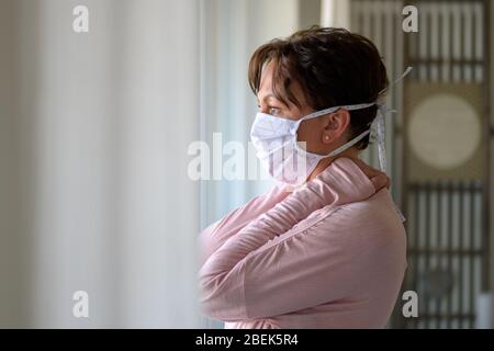 Frau, die eine chirurgische Gesichtsmaske gegen das Coronavirus oder Covid-19 trägt, schützt sich während der globalen Pandemie vor der Atemwegserkrankung Stockfoto
