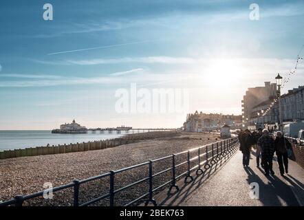 Großbritannien, England, East Sussex, Eastbourne. Fußgänger auf der Strandpromenade mit dem Pier im hinteren Teil von SHOT Stockfoto