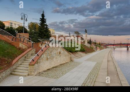 Gorzow Wielkopolski, ger.: Landsberg an der Warthe, Lubusz Provinz, Polen. Ein Boulevard am Ufer der Warta. Die Altstadtbrücke im Hintergrund. Stockfoto