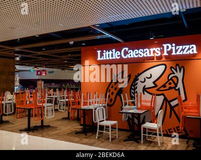 SINGAPUR – 9. April 2020 – Stapelstühle im geschlossenen Dine-in-Bereich des Little Caesar’s Pizza Restaurant in Thompson plaza. Nur Mitnehmen ist erlaubt Stockfoto