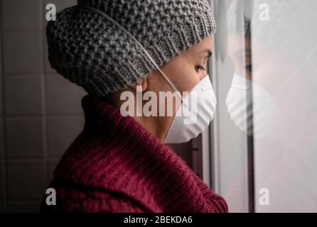 Frau mit Gesichtsmasken drinnen zu Hause, Corona-Virus und Quarantäne-Konzept Stockfoto