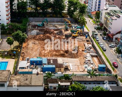 SINGAPUR – 23 JAN 2020 - Luftaufnahme einer Baustelle in einem Vorort von Singapur. Schwere Geräte und Wohnräume sind sichtbar Stockfoto