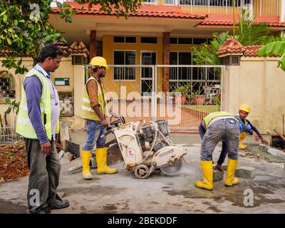 SINGAPUR – 5. MÄRZ 2020 – Bauarbeiter in gut sichtbarer Schutzausrüstung auf einem Baustelle in einem Wohnviertel Stockfoto