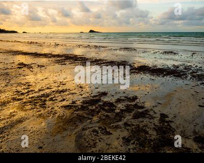 BINTAN, INDONESIEN – 7. MÄRZ 2020 – Tar-Kugeln und Ölschlamm aus Meeresölverschüttungen werden am Strand von Lagoi bei schönem Sonnenuntergang gespült und verursachen Umweltverschmutzung Stockfoto