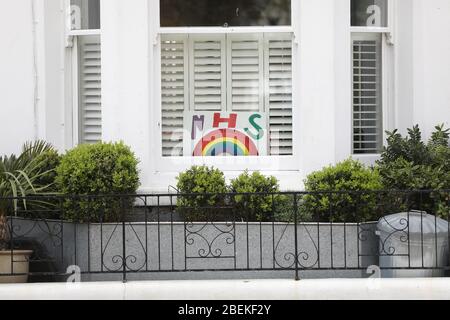 Brighton, Großbritannien. April 2020. Eine künstlerische Regenbogenzeichnung in einem Hausfenster in Brighton. Der Regenbogen ist zu einem Symbol der Unterstützung für Menschen geworden, die Solidarität mit den NHS-Arbeitern an vorderster Front zeigen wollen. Quelle: James Boardman/Alamy Live News Stockfoto